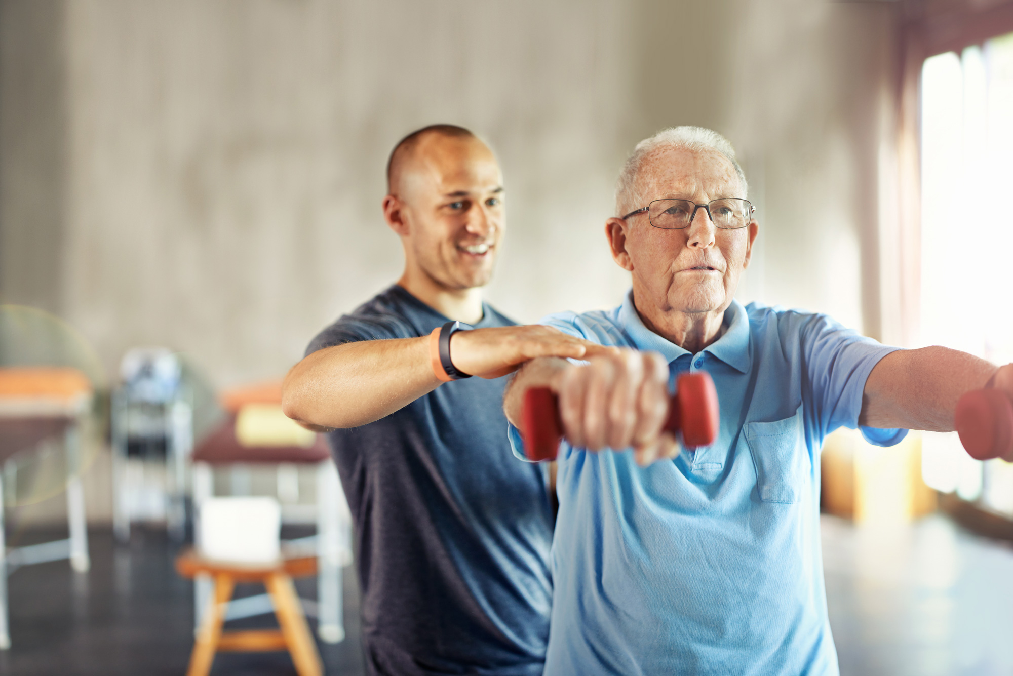 Shot of a senior man working out with the help of a trainer