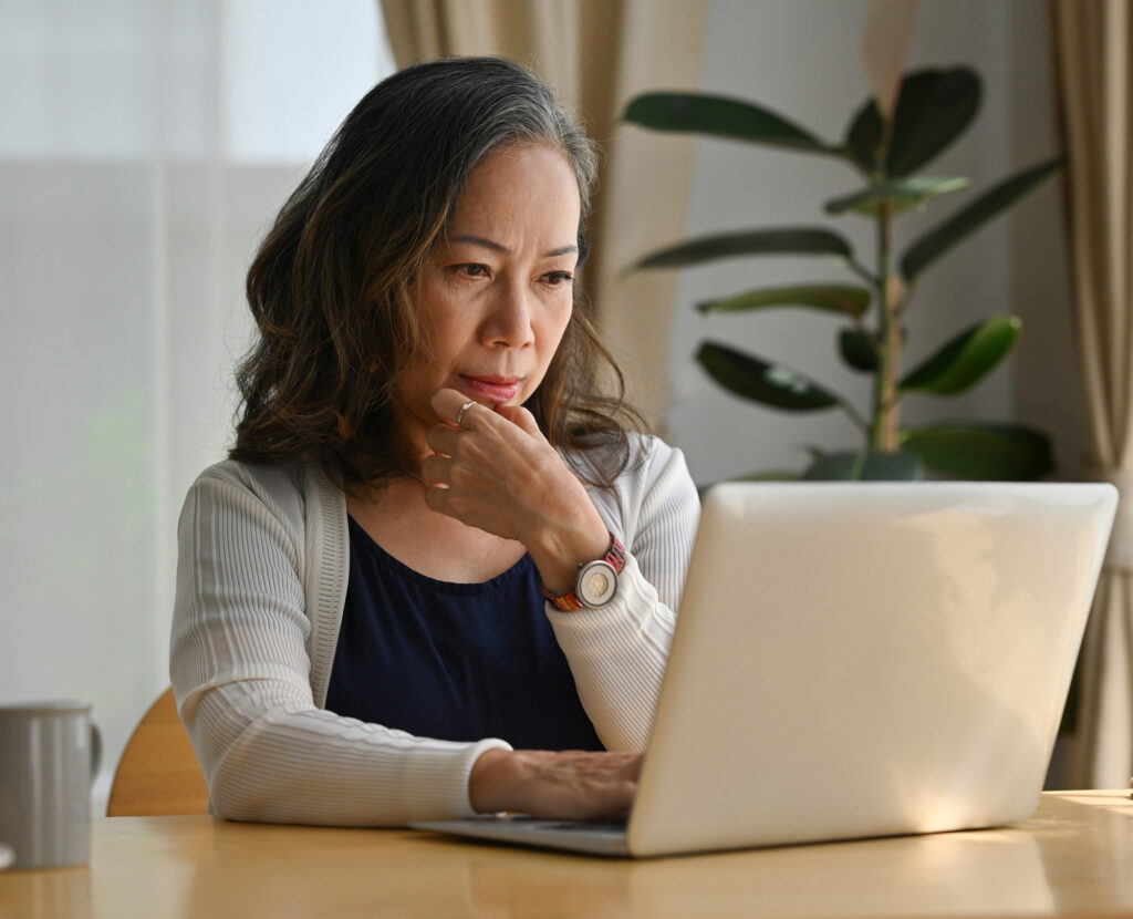 Old woman work at home using notebook computer