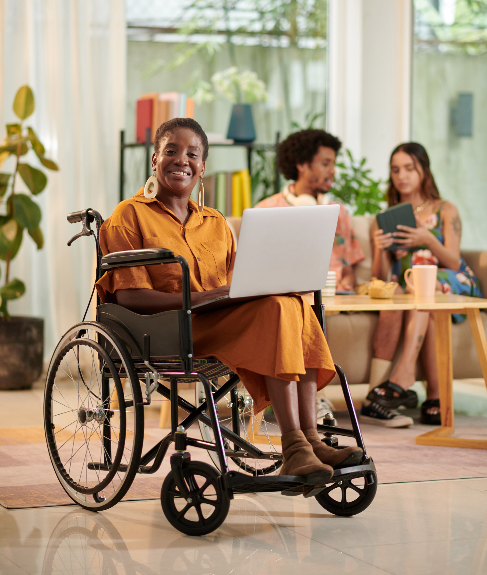 Smiling Black woman with disability meeting with coworkers to discuss project